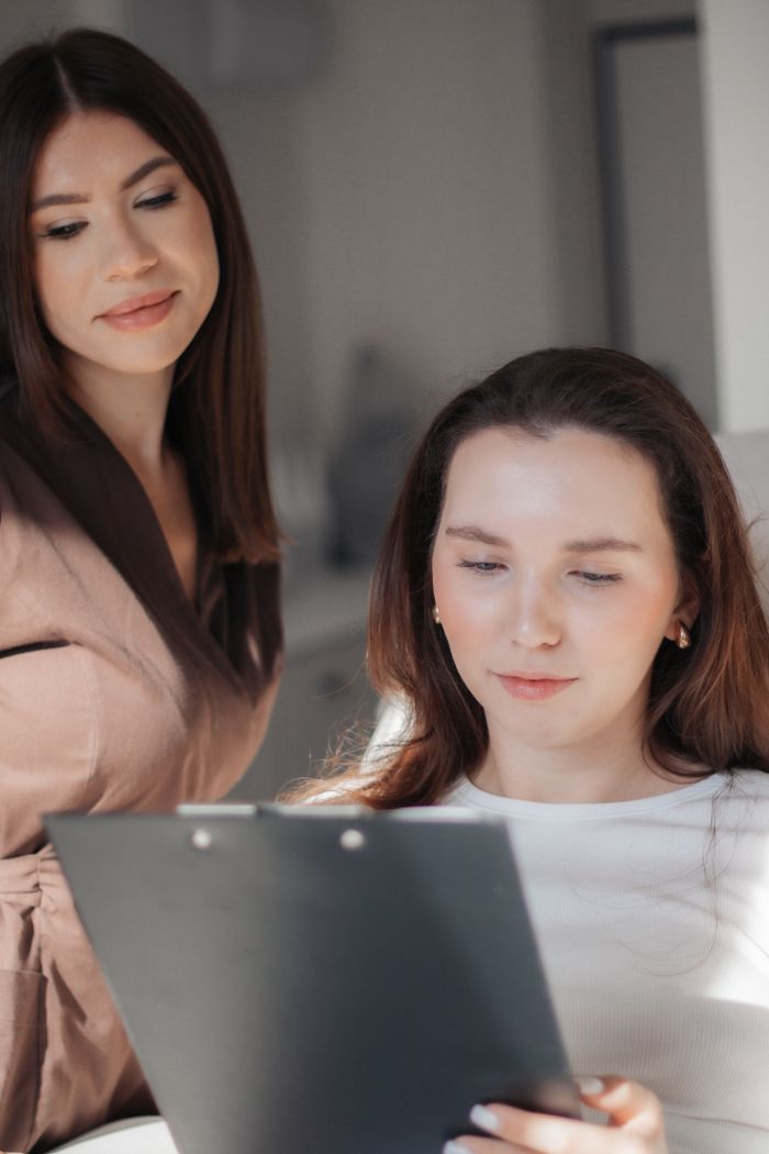 Two women reviewing documents together in a bright indoor setting.